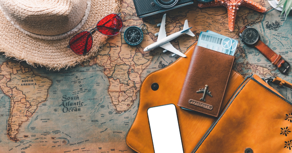 Articole de călătorie plasate pe o hartă, inclusiv un pașaport, un aparat foto și un glob, simbolizând pregătirile pentru circuite turistice memorabile în 2025.
