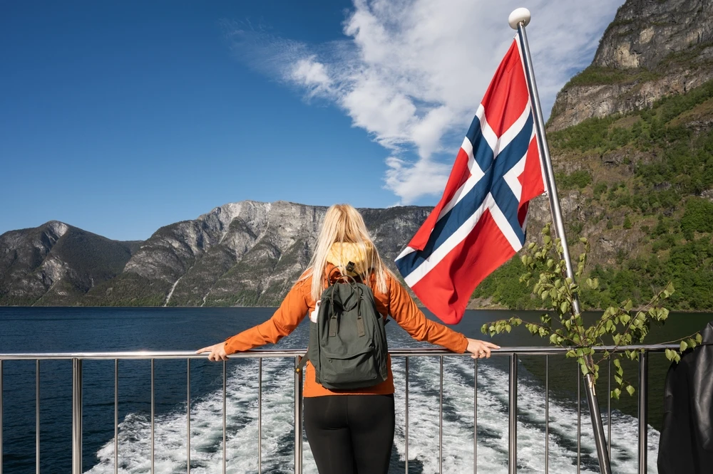 turista pe vas de croaziera navigand prin fiordurile Norvegiei